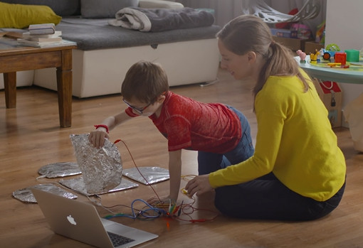 Unha nai e o seu fillo realizan unha actividade educativa tecnolóxica.